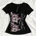 Schwarzes Shirt mit floralem Lilien-Print und geschwungenem Schriftzug